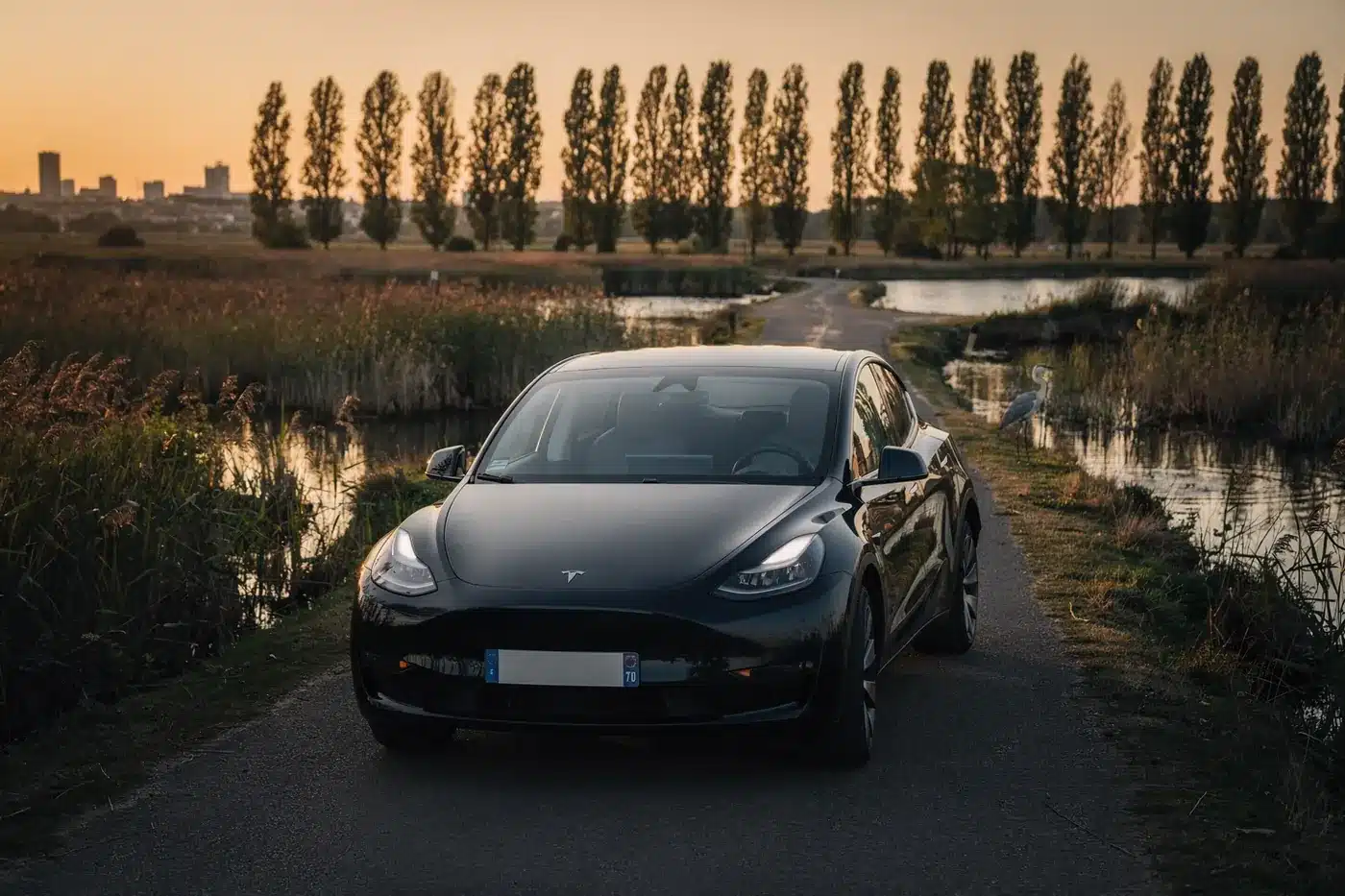 VTC Bruges, berline noire sur une petite route des marais de Bruges au coucher du soleil